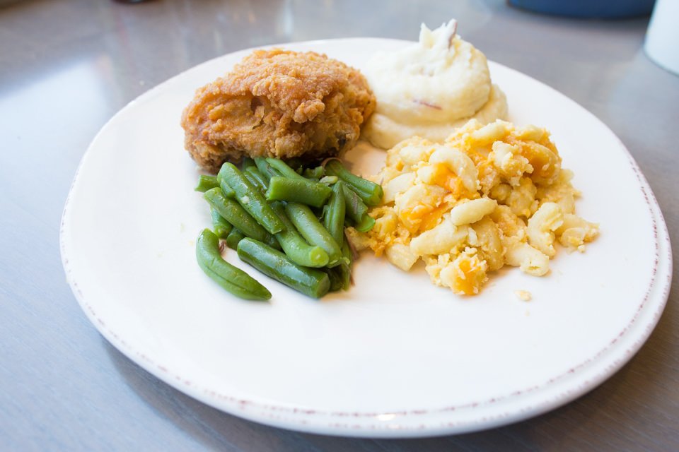 plate of food with fried chicken, green beans, and mashed potatoes