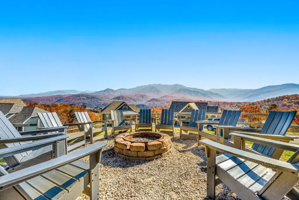 outdoor firepit surrounded by grey chairs and beautiful fall foliage