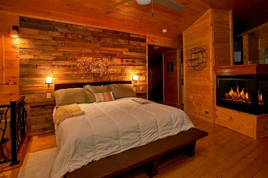 bedroom with iron railing and fireplace next to bed