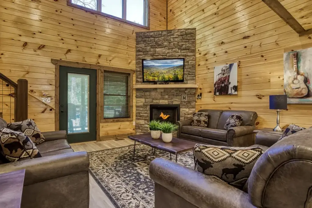 stone fireplace in living room with gray couches and plants