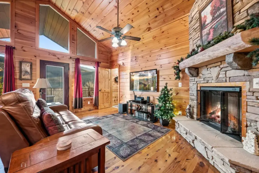 cozy fireplace in living room with red and brown curtains and brown leather chair