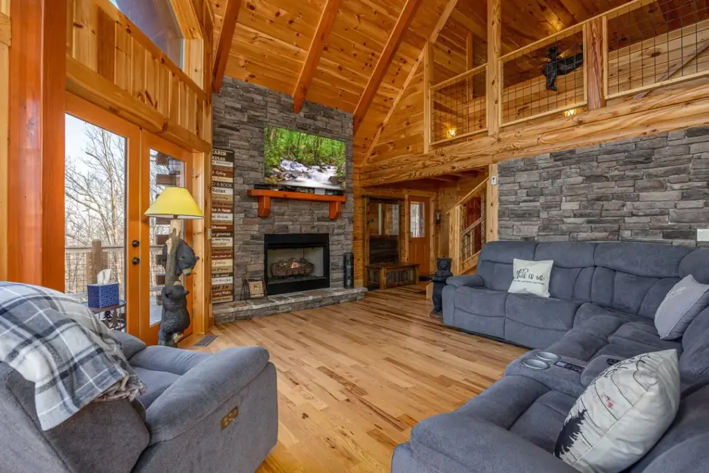 grey velvet couch with fireplace across from it and tv above the fireplace