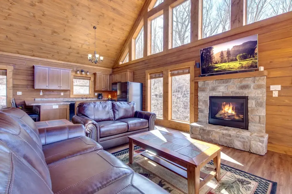 fireplace with tv above it with two brown leather couches