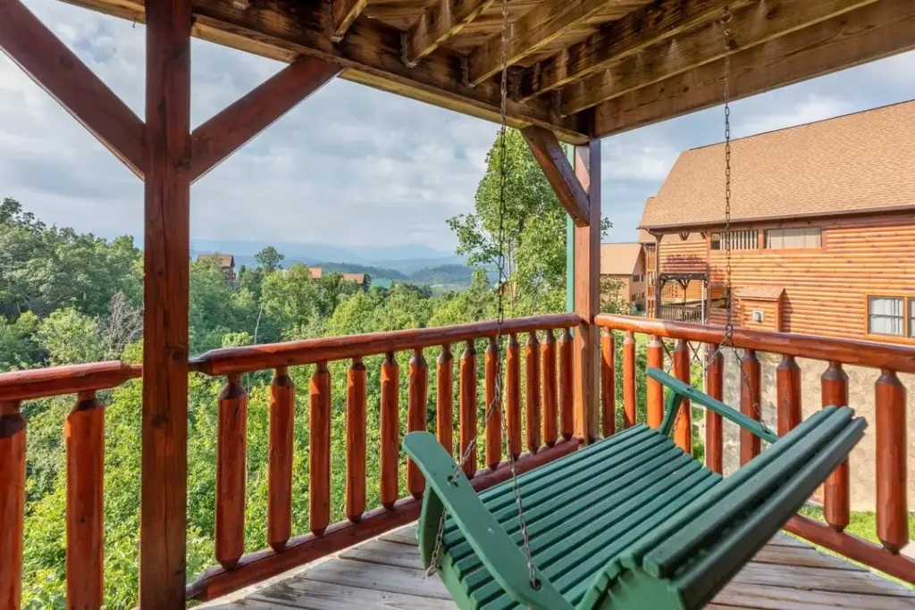 green swinging bench on balcony overlooking the mountains and trees