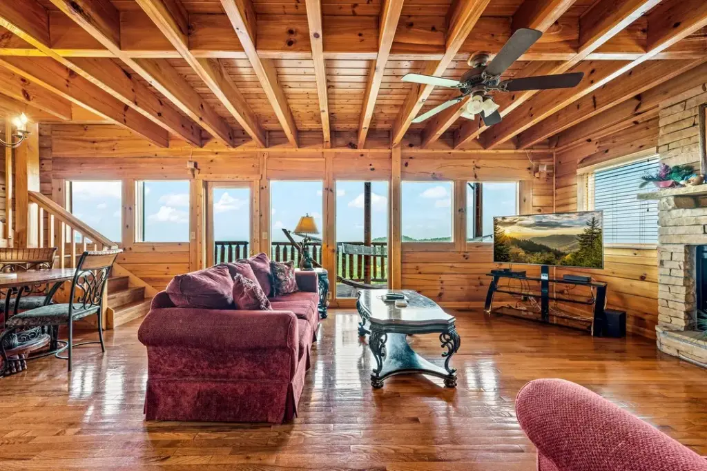 second floor living room with balcony overlooking the trees and skies